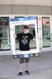 A Willems Student Marketing Team member shows the Romenesko Instagram Frame at Mile 2.